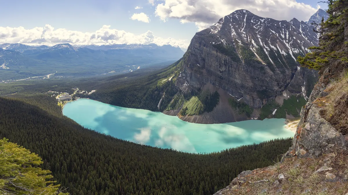 Panorama of turquoise Lake Louise below glaciated peaks in Banff National Park