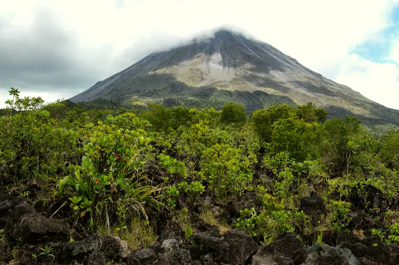 Arenal Volcano above green rainforest, a stop on this Costa Rica itinerary