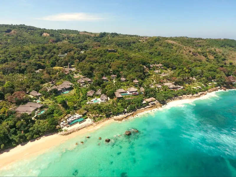 Aerial view of the turquoise beach and forested coast at Nihi Sumba