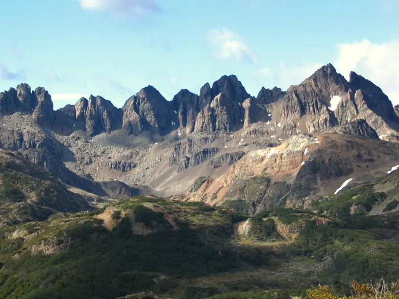 The jagged Dientes de Navarino peaks above green slopes on Navarino Island