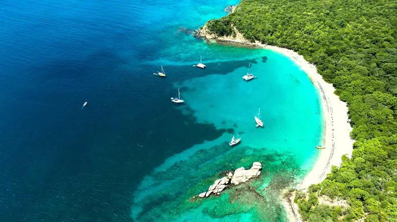 Boats at anchor in clear turquoise water at Anse La Roche, Carriacou, Grenada