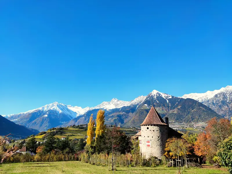A castle among fields below the mountains near Merano